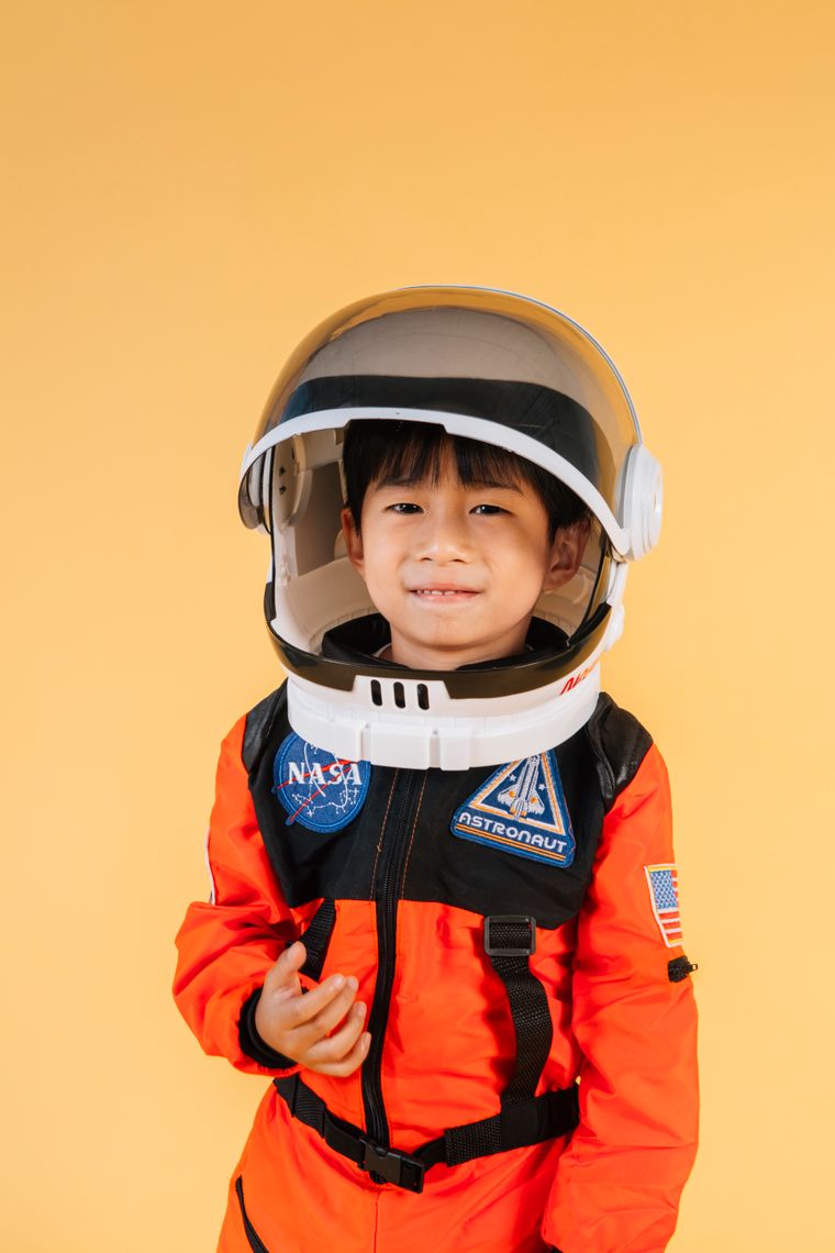 A boy in an orange space suit and helmet