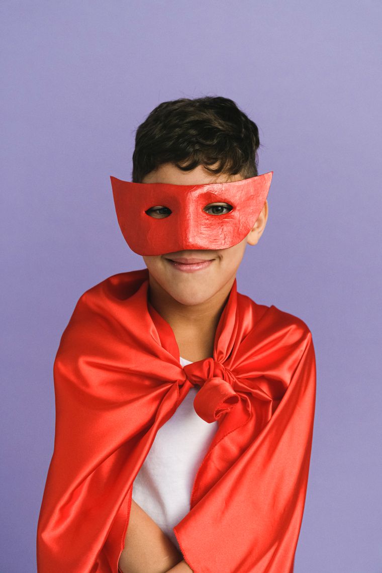 A boy in a red cape and mask