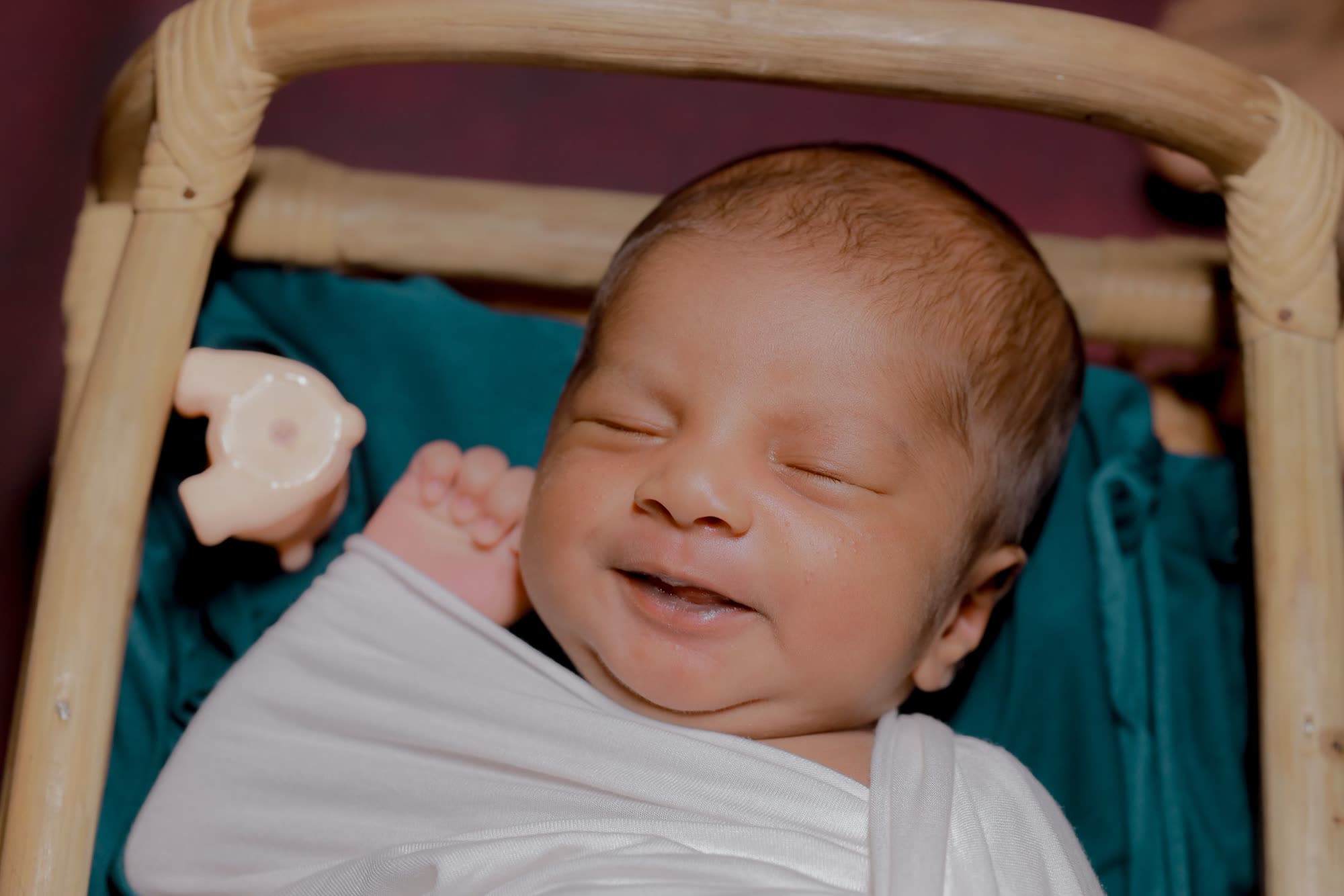 A newborn baby smiling in his sleep