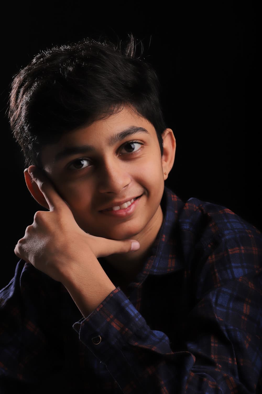 A smiling teenage boy in a checked shirt